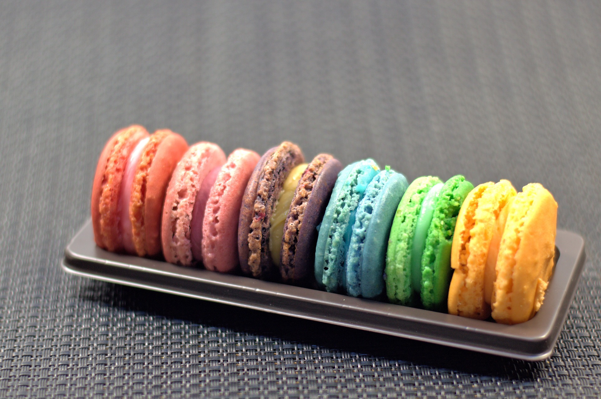 Rainbow color macaroons served in a row.