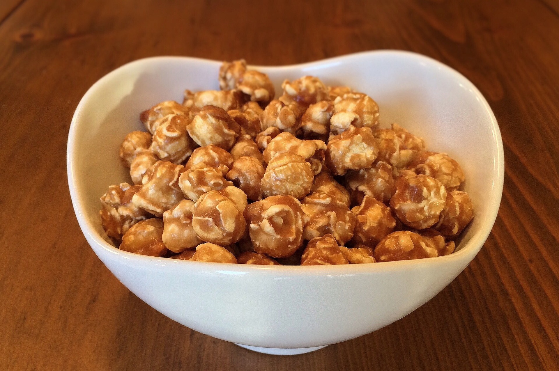 Caramel popcorn in a white bowl.